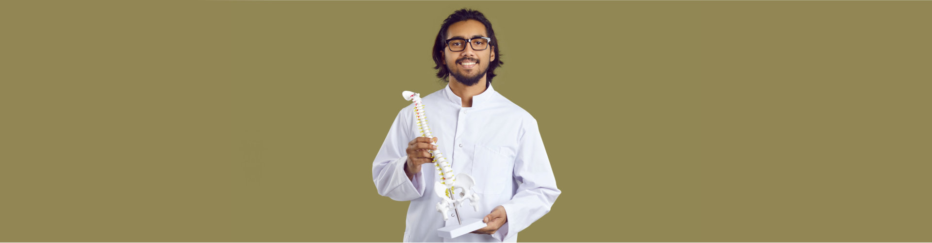 smiling doctor carrying a spine model